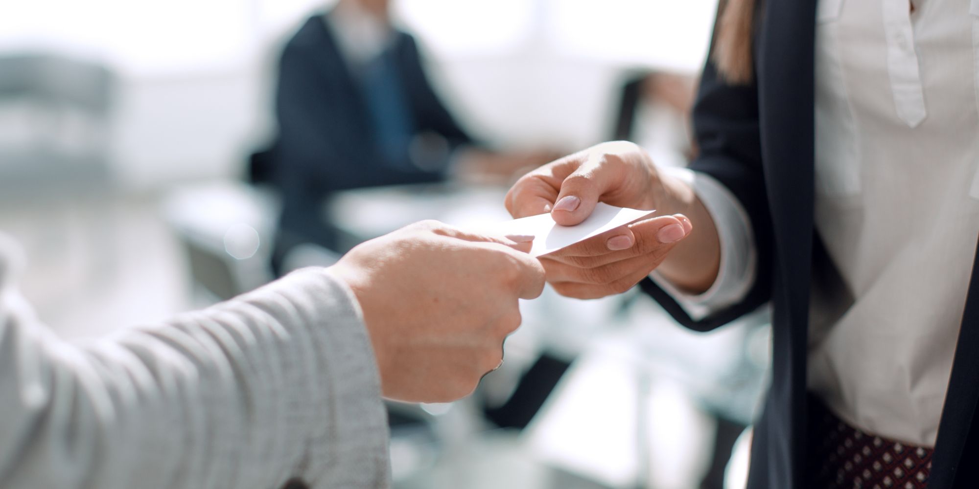 Two people exchange business cards (stock image)